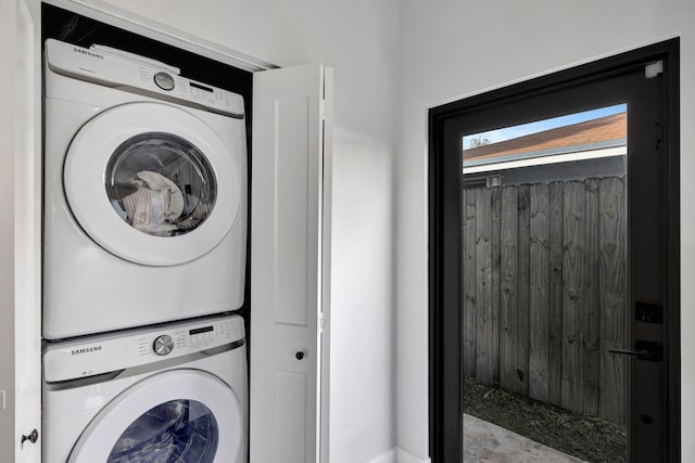 washroom with stacked washing maching and dryer