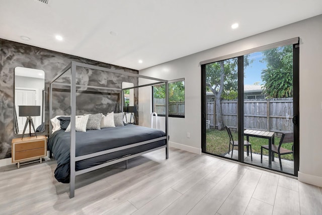 bedroom with access to outside and light wood-type flooring