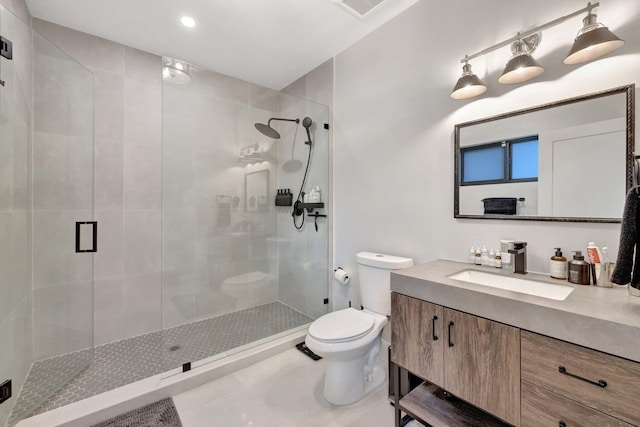 bathroom featuring tile patterned flooring, vanity, toilet, and a shower with shower door