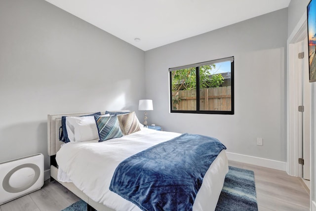 bedroom featuring light hardwood / wood-style flooring and vaulted ceiling