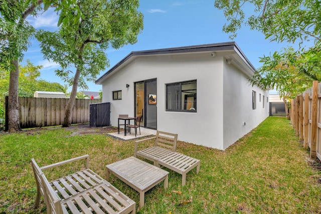 rear view of house with a lawn and a patio area