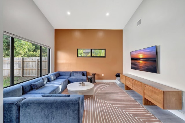 living room featuring a towering ceiling, light hardwood / wood-style flooring, and a notable chandelier