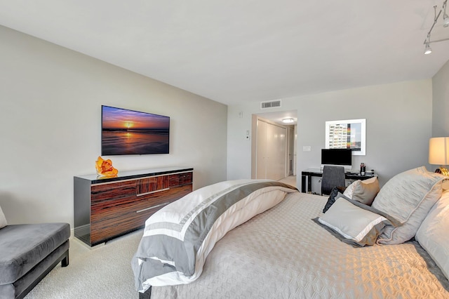 bedroom with light carpet and track lighting