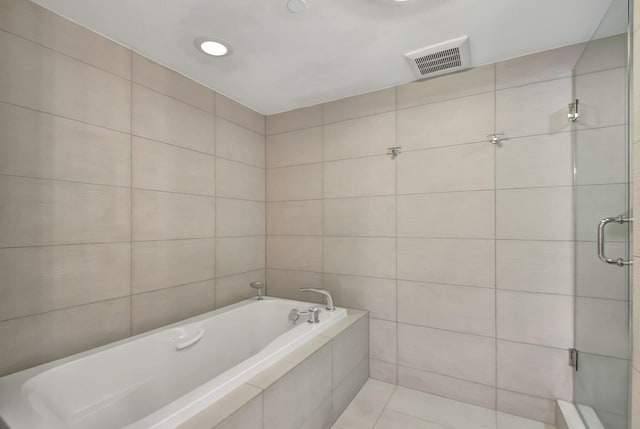 bathroom with shower with separate bathtub, tile walls, and tile patterned floors