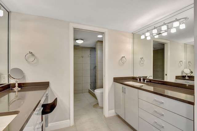 bathroom featuring vanity, tile patterned floors, toilet, and tiled shower