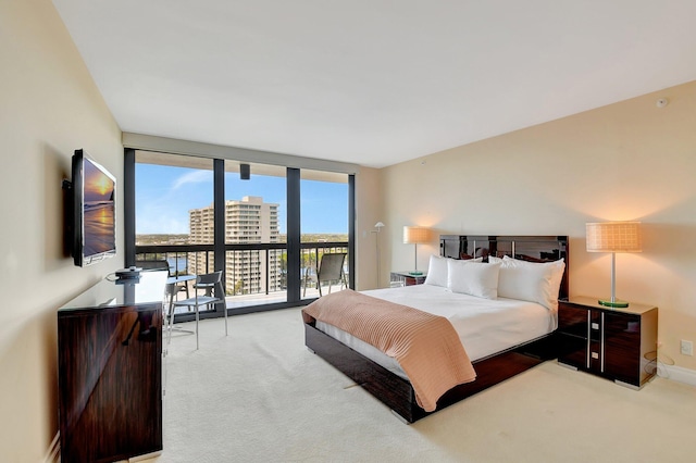 carpeted bedroom featuring a wall of windows and access to outside