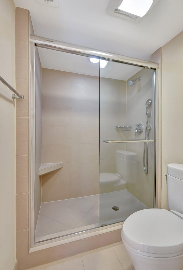 bathroom with an enclosed shower and toilet