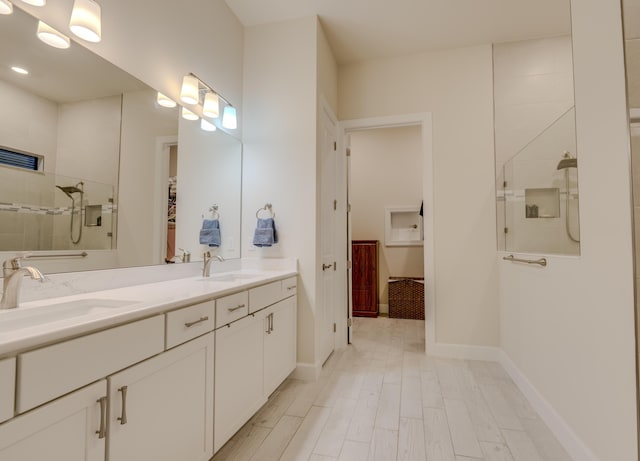 bathroom featuring hardwood / wood-style flooring, vanity, and walk in shower