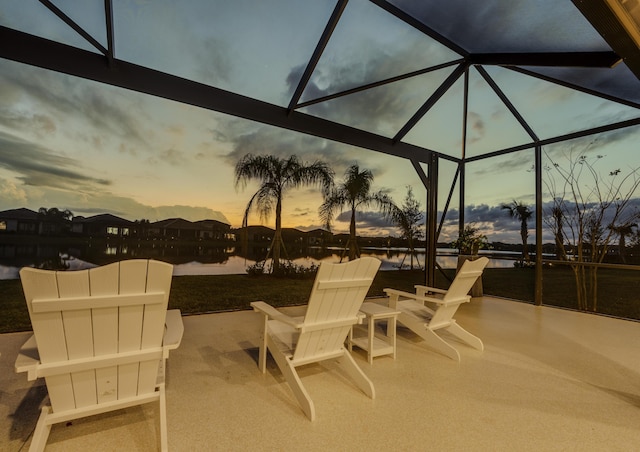 patio terrace at dusk with glass enclosure and a water view