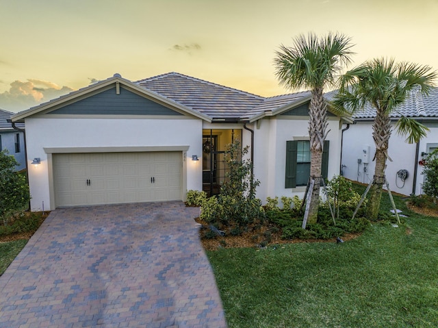 view of front of home with a garage and a yard