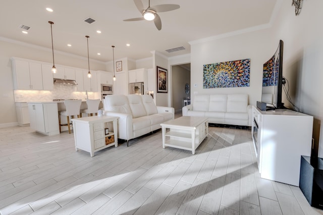 living room featuring ceiling fan and crown molding