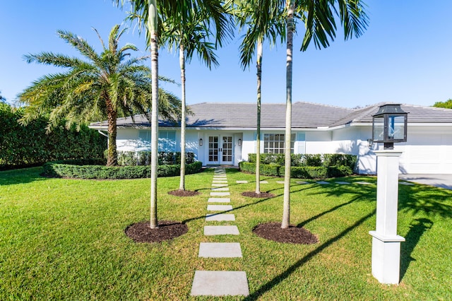 ranch-style house featuring french doors and a front lawn