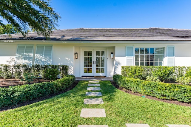 property entrance featuring french doors and a yard