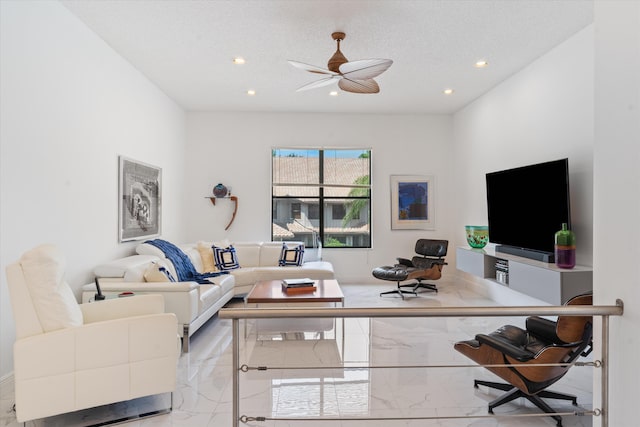 living room featuring a textured ceiling and ceiling fan