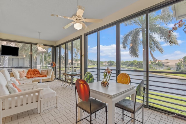 sunroom / solarium with a water view and ceiling fan