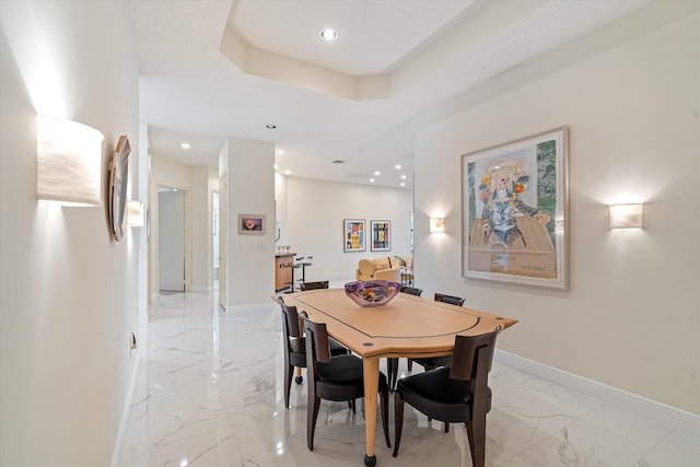 dining space featuring a raised ceiling