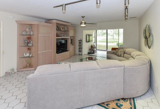 living room with a textured ceiling and ceiling fan