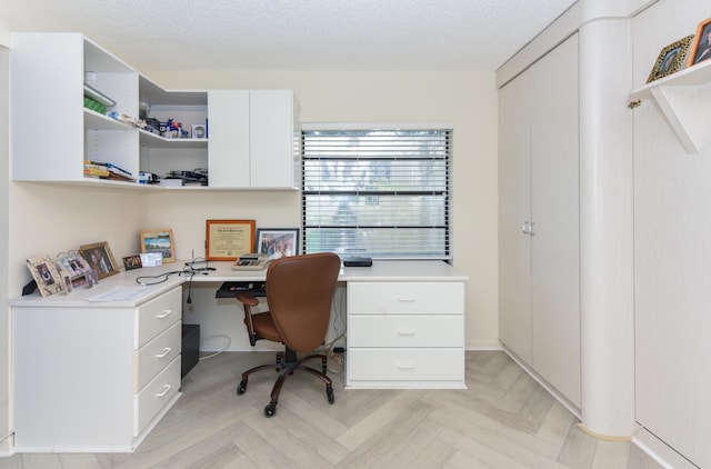 office featuring light parquet floors and a textured ceiling