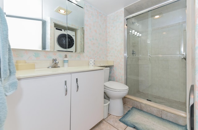 bathroom with vanity, a shower with door, tile patterned flooring, toilet, and stacked washer / dryer