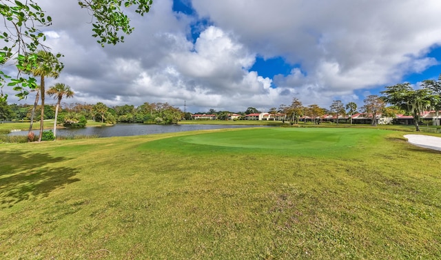 surrounding community with a yard and a water view