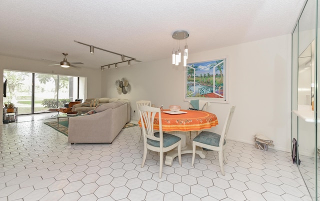 dining space with ceiling fan, a textured ceiling, and track lighting