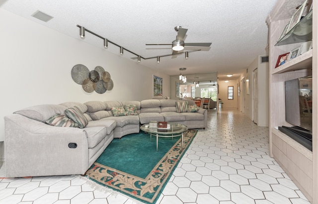 living room with ceiling fan, track lighting, and a textured ceiling