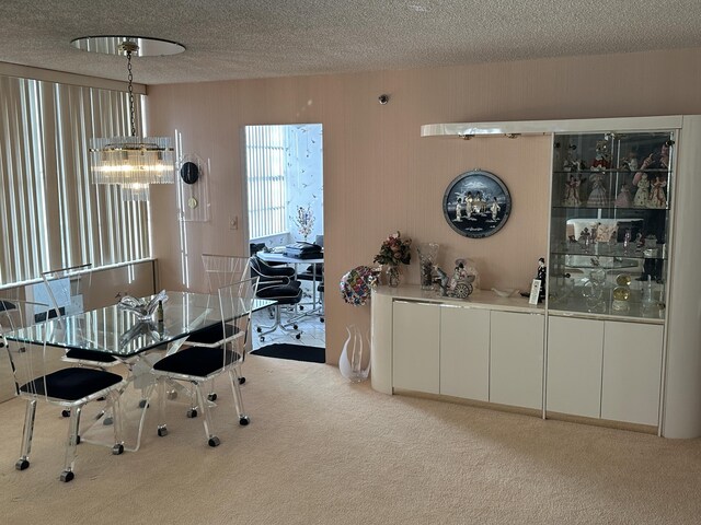 dining space with light colored carpet, a textured ceiling, and an inviting chandelier