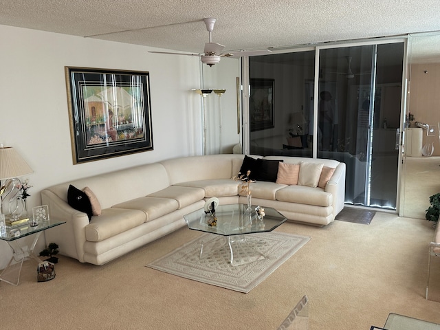 carpeted living room with ceiling fan and a textured ceiling