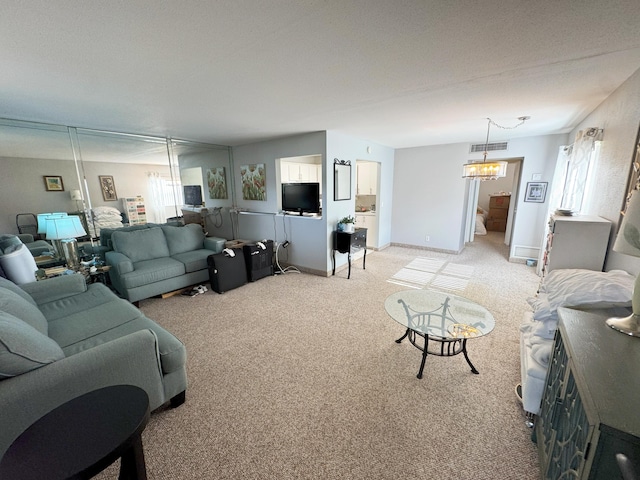 carpeted living room featuring a chandelier