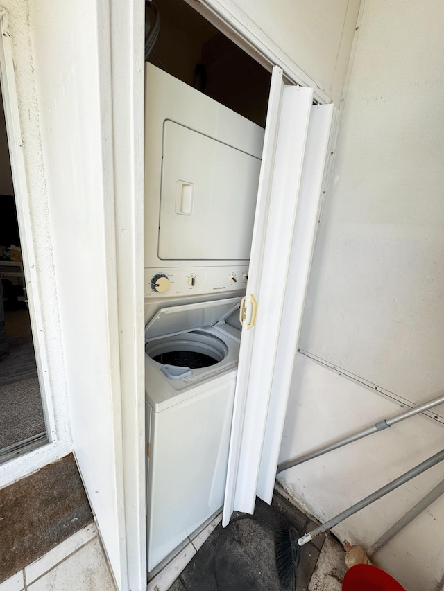 clothes washing area with stacked washer and clothes dryer