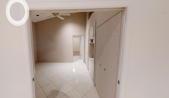 hallway with light tile patterned flooring and lofted ceiling