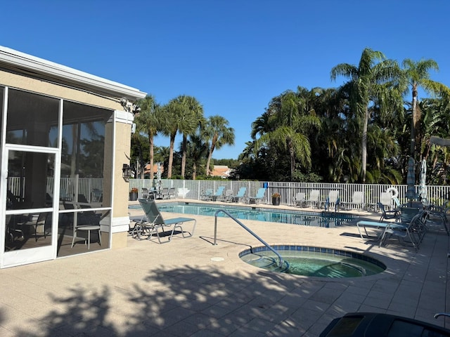 view of swimming pool featuring a patio and a hot tub