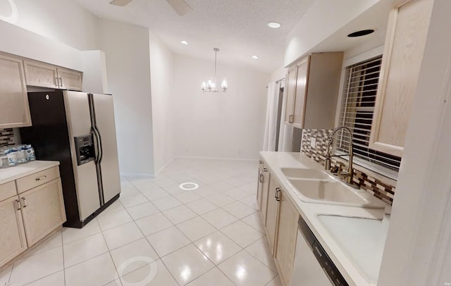 kitchen featuring light brown cabinets, hanging light fixtures, sink, decorative backsplash, and appliances with stainless steel finishes