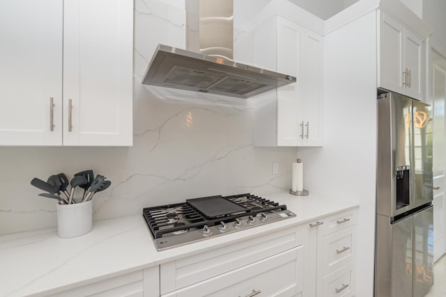 kitchen featuring extractor fan, tasteful backsplash, stainless steel appliances, light stone countertops, and white cabinets