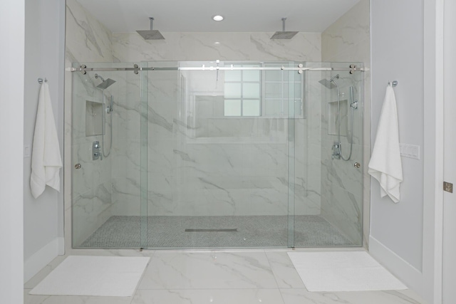 full bath with marble finish floor, a stall shower, and baseboards