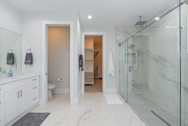 bathroom featuring a walk in closet, toilet, marble finish floor, a marble finish shower, and baseboards