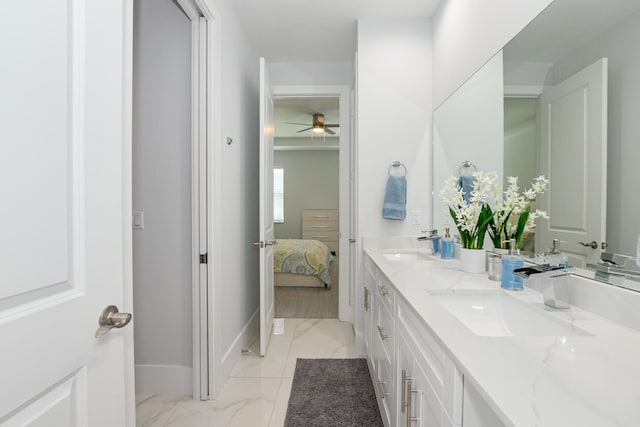 ensuite bathroom with a ceiling fan, baseboards, marble finish floor, and a sink