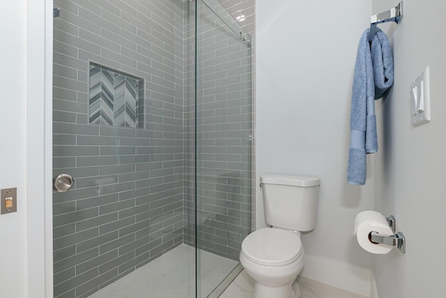 bathroom featuring a tile shower and toilet