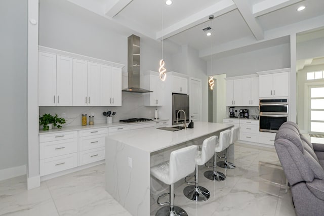 kitchen with a high ceiling, wall chimney range hood, marble finish floor, and backsplash