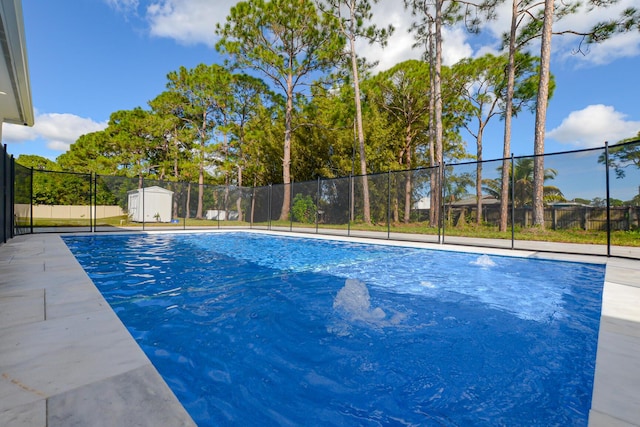 view of swimming pool with a storage unit, a fenced in pool, an outbuilding, and a fenced backyard