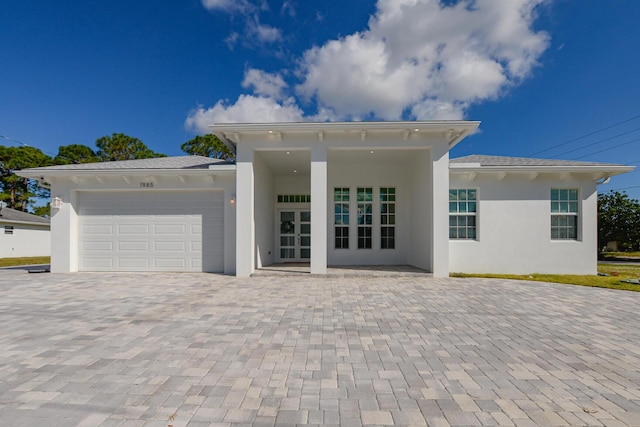 view of front of home with a garage and french doors