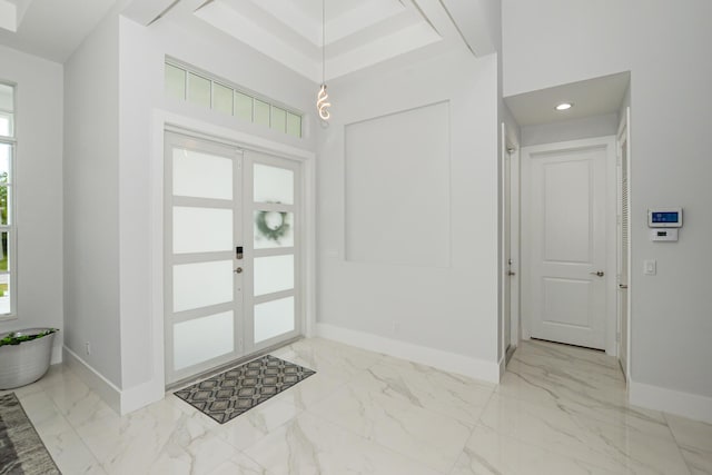 entrance foyer featuring marble finish floor, french doors, and baseboards