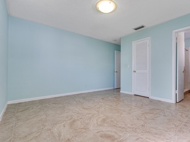 unfurnished bedroom featuring a textured ceiling and a closet