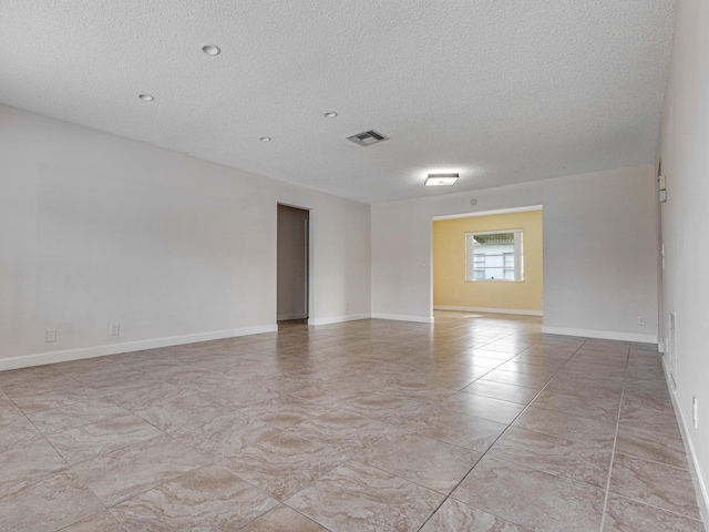 unfurnished room with a textured ceiling