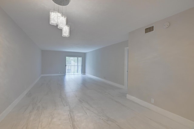 spare room featuring a chandelier