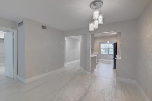 unfurnished dining area with an inviting chandelier