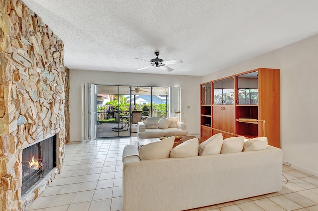 living room with a fireplace, light tile patterned floors, a wealth of natural light, and ceiling fan