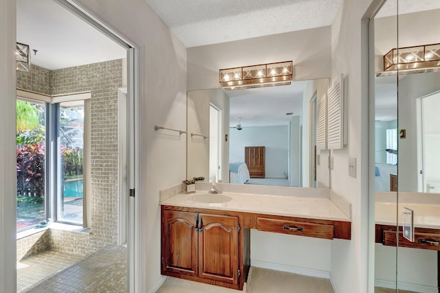 bathroom featuring ceiling fan, a textured ceiling, and vanity