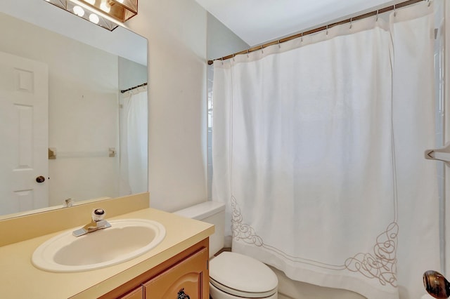 bathroom with curtained shower, vanity, and toilet