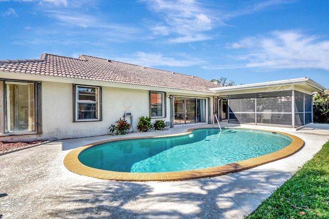 view of swimming pool with a patio area and a sunroom